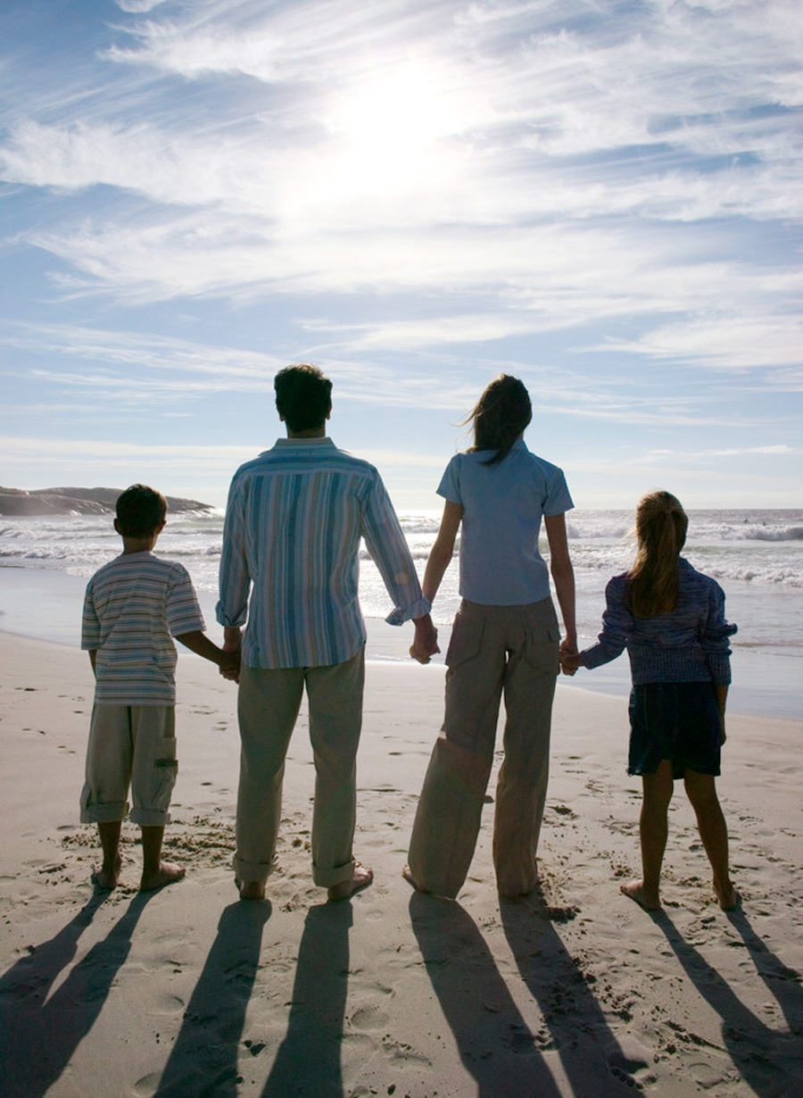 Happy family holding hands by the shoreline